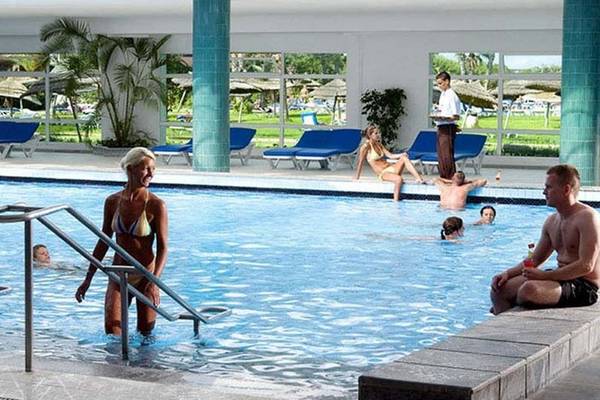 Innenpool des Sahara Beach AquaPark Resorts mit mehreren Gästen, die schwimmen und entspannen.