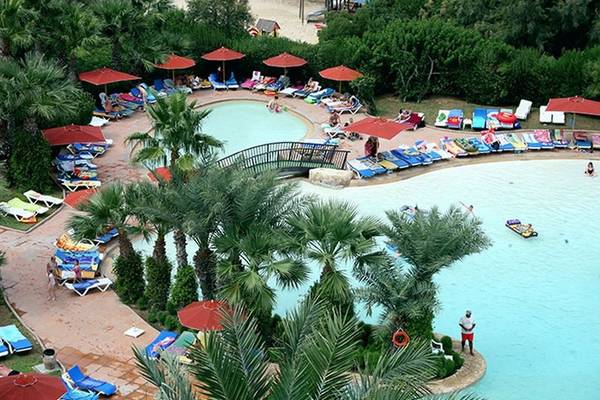 Einen Überblick über das Sahara Beach AquaPark Resort mit Swimmingpool, Liegestühlen und Sonnenschirmen.