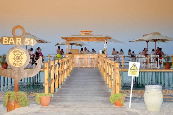 Sahara Beach AquaPark Resort Bar 51 am Wasser mit Gästen, Sonnenschirmen und Tischen.
