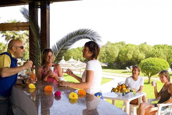 Freude und Unterhaltung auf der Terrasse des Sahara Beach AquaPark Resorts mit Gästen und Getränken.