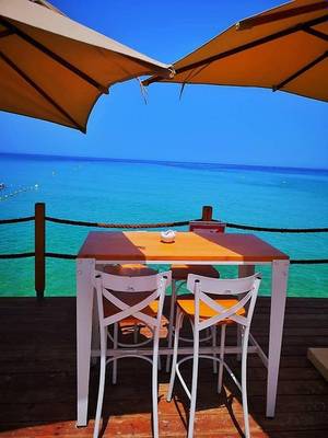 Terrasse des Sahara Beach AquaPark Resorts mit Tisch, Stühlen und Meerblick