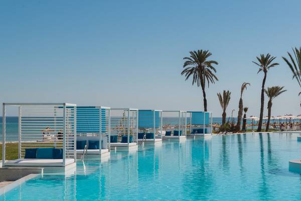 Infinity-Pool des Iberostar Selection Kuriat Palace Hotels mit Liegen und Palmen im Hintergrund