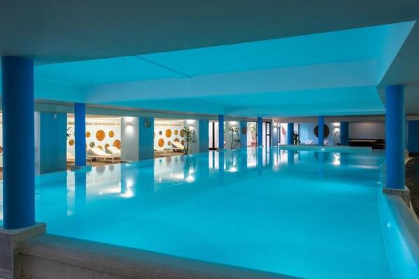 Innenpool im Iberostar Selection Kuriat Palace Hotel mit blauen Säulen und Liegestühlen