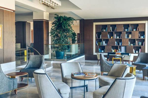 Lobby des Iberostar Selection Kuriat Palace Hotels mit Möbeln und Bücherregal