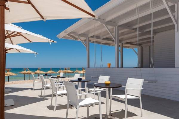 Außenbereich der Iberostar Selection Kuriat Palace Strandbar mit weißen Stühlen und Tischen