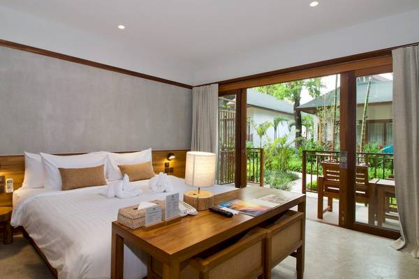 Hotelzimmer im Banana Fan Sea Resort mit großem Bett und Balkonzugang.