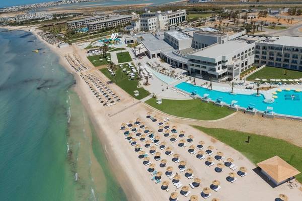 Luftaufnahme des Iberostar Selection Kuriat Palace Resorts mit großem Pool und vielen Sonnenschirmen am Strand.