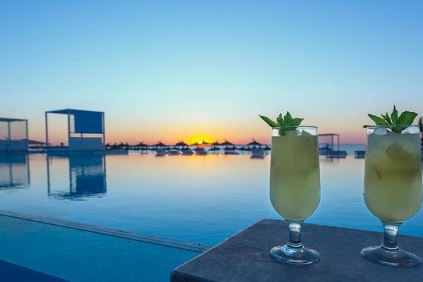Zwei Cocktails mit Minzblättern auf der Hotelbar am Pool bei Sonnenuntergang im Iberostar Selection Kuriat Palace.