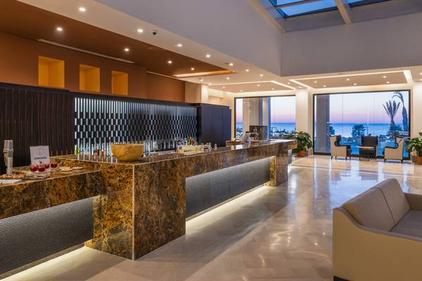 Lobby des Iberostar Selection Kuriat Palace Hotels mit großer Bar und Blick auf das Meer.