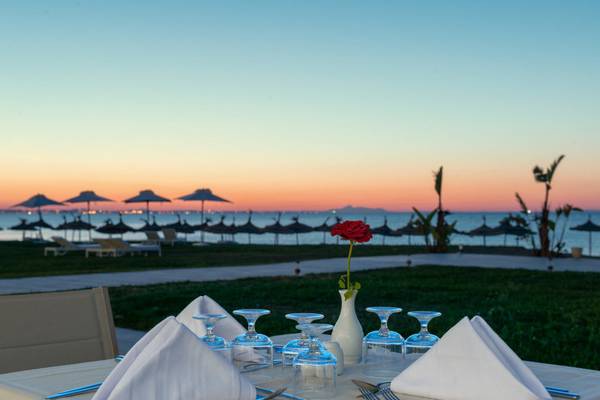 Tisch im Iberostar Selection Kuriat Palace mit Blick auf das Meer und eine rote Rose in einer Vase.