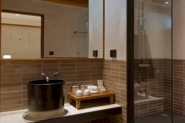 Badezimmer im Banana Fan Sea Resort mit schwarzem Waschbecken und braunen Fliesen.