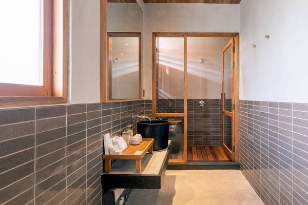 Dusche Bereich im Banana Fan Sea Resort mit grauen Ziegelwänden und hölzernen Elementen.