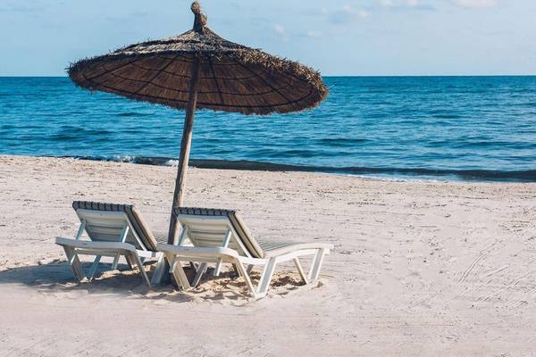 Zwei Sonnenliegen auf dem Strand mit einem Sonnenschirm im Iberostar Selection Kantaoui Bay Hotel
