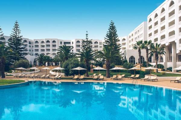 Außenpool-Bereich des Iberostar Selection Kantaoui Bay Hotels mit Sonnenliegen und Sonnenschirmen.
