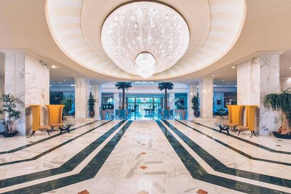 Empfangsbereich des Hotels Iberostar Selection Kantaoui Bay mit großem Kronleuchter und Marmorboden.