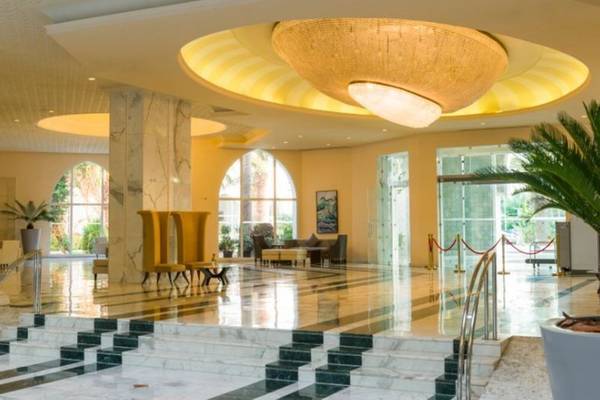 Empfangsbereich des Iberostar Selection Kantaoui Bay Hotels mit einer großen Deckenleuchte und Marmorboden.