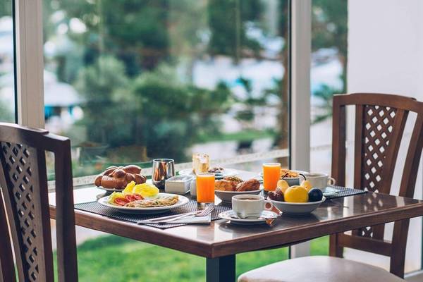 Frühstückstisch im Iberostar Selection Kantaoui Bay mit Blick auf eine grüne Rasenfläche.