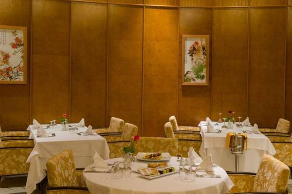 Speisesaal des Iberostar Selection Kantaoui Bay mit gedeckten Tischen und dekorativen Bildern an der Wand.