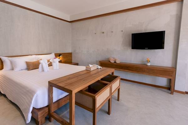 Innenansicht eines Hotelzimmers mit Doppelbett, Nachttischen, Fernseher an der Wand und Dekor