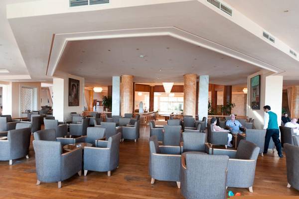 Loungebereich des Sentido Bellevue Park Hotels mit vielen grauen Sesseln und Holzboden.