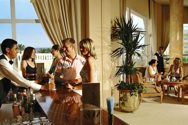 Mehrere Gäste unterhalten sich an der Bar des Sentido Bellevue Park Hotels.