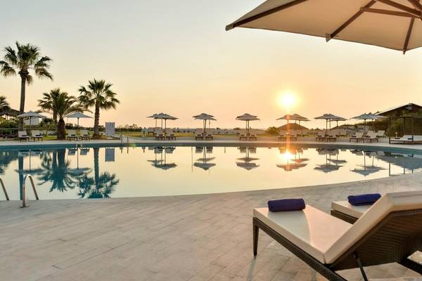 Abendsonne über dem Pool des Iberostar Selection Diar El Andalous mit Sonnenschirmen und Liegen.
