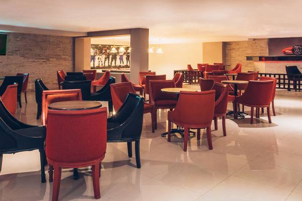 Loungebereich des Iberostar Selection Diar El Andalous Hotel mit roten Stühlen und Tischen.