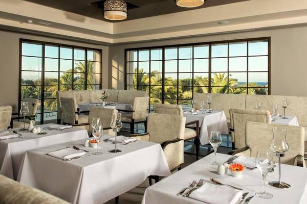 Innenansicht des Restaurants im Iberostar Selection Diar El Andalous Hotel mit großen Fenstern und Meerblick.