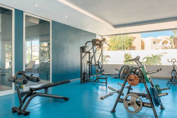 Fitnessbereich im Iberostar Selection Diar El Andalous Hotel mit modernen Geräten und Glaswänden.