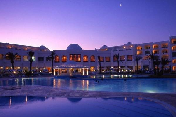 Das Mahdia Palace Thalasso Hotel bei Nacht mit beleuchtetem Pool und Palmen