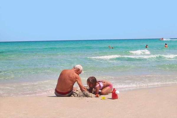 Großvater und Enkelin bauen eine Sandburg am Strand des Mahdia Palace Thalasso