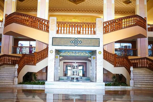 Foyer des Mahdia Palace Thalasso mit einer zentralen Wasserfontäne und zwei Holztreppenhäusern.