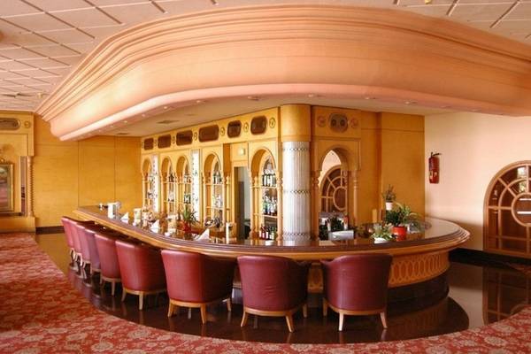 Die elegante Bar im Mahdia Palace Thalasso Hotel mit roten Stühlen und üppiger Dekoration.