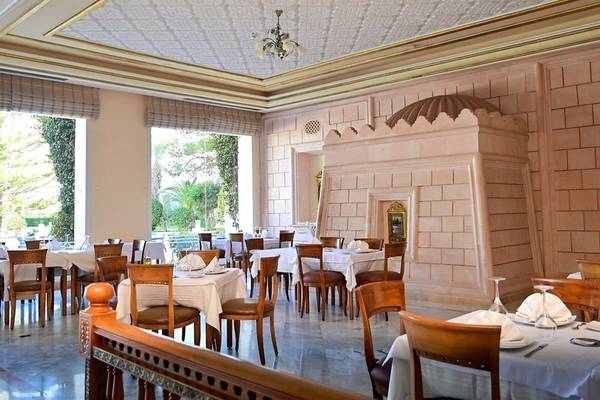 Innenansicht des Restaurants des Mahdia Palace Thalasso mit gedeckten Tischen und goldenen Details.