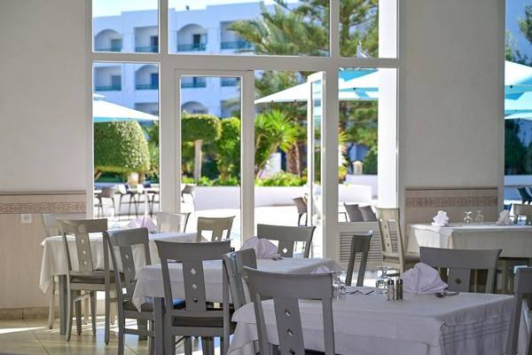 Restaurantbereich des Mahdia Palace Thalasso Hotels mit Tisch und Stühlen, gedeckt für Gäste.