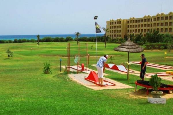 Golfplatz am Mahdia Palace Thalasso Hotel mit zwei Spielern und Blick auf das Meer.