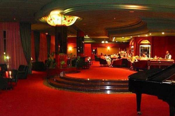 Loungebereich des Mahdia Palace Thalasso Hotels mit rotem Teppich und Klavier.