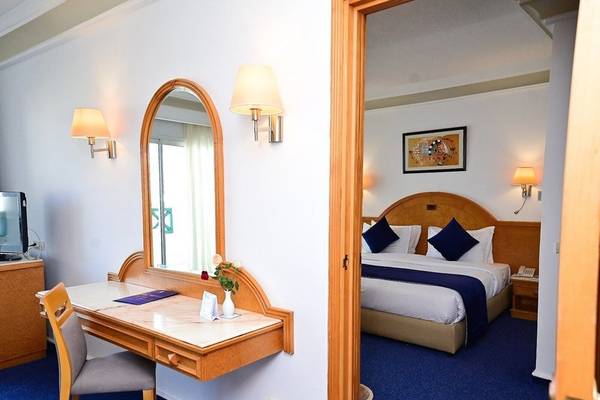 Innenansicht eines Hotelzimmers im Mahdia Palace Thalasso mit Schreibtisch, Stuhl, Spiegel und Bett