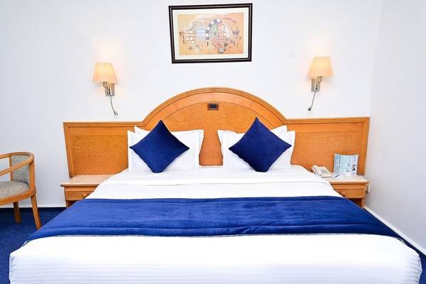 Hotelzimmer im Mahdia Palace Thalasso mit Doppelbett, blauer Bettwäsche und weißem Kopfteil.