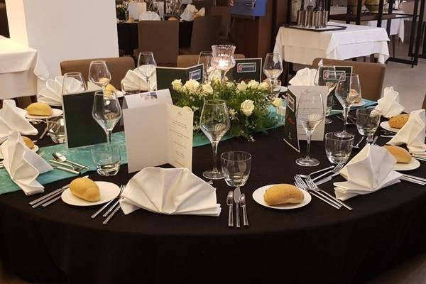 Rundes Essenstisch im Hotel Orangers Garden Villas & Bungalows mit gedeckten Plätzen, Geschirr, Besteck und Blumen.