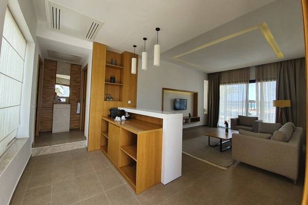 Wohnbereich der Orangers Garden Villas mit Sofa, Tisch, Fernseher und Bar.