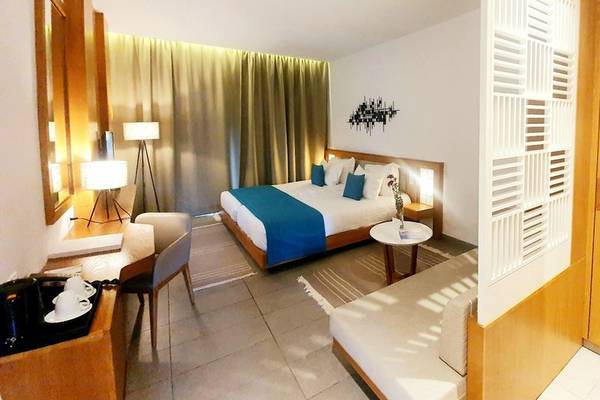 Hotelzimmer von Orangers Garden Villas & Bungalows mit Bett, Schreibtisch und Sofa