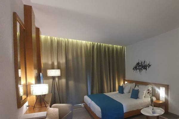 Foto eines Zimmers im Orangers Garden Villas & Bungalows mit einem Bett, Kissen, Lampen und einem Wandbild.