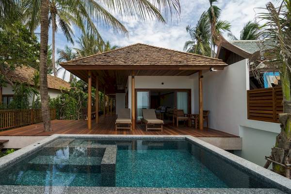 Außenbereich des Banana Fan Sea Resort mit Pool, Liegestühlen und Holzdekoration