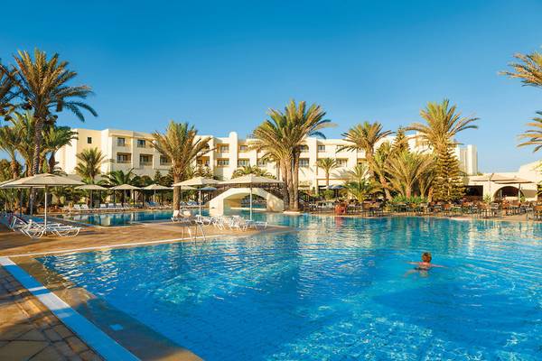Außenpoolbereich des Aldiana Club Djerba Atlantide Hotels mit Palmen und Sonnenliegen