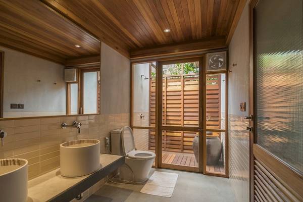 Ein Badezimmer mit zwei Waschbecken, einer Toilette und einer Glastür, die zu einer Dusche führt.