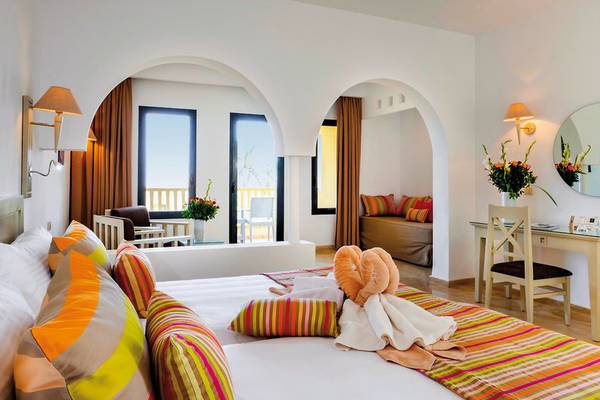 Ein Zimmer im Aldiana Club Djerba Atlantide Hotel mit Bett, Schreibtisch, Spiegel und Balkon