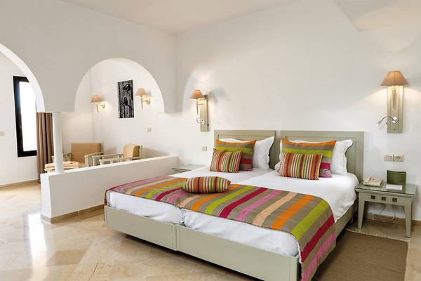 Schlafzimmer im Aldiana Club Djerba Atlantide mit zwei Betten, bunten Kissen und Nachttischen