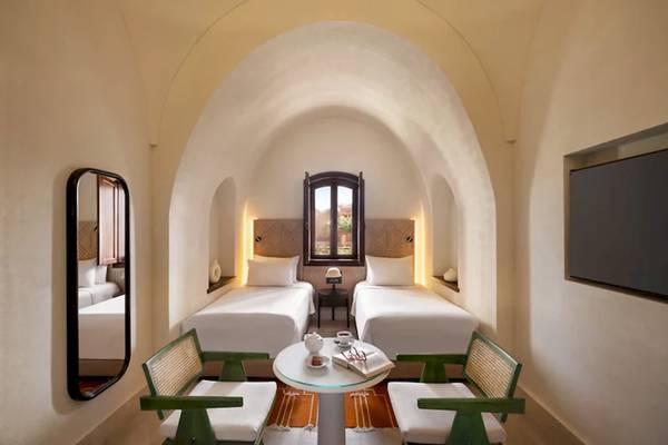 Doppelzimmer im Mövenpick Resort El Quseir mit zwei Betten, einem Tisch und einem Spiegel