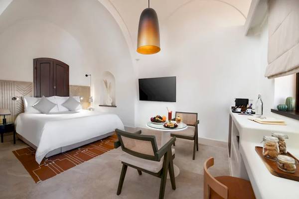 Innenansicht der Suite im Mövenpick Resort El Quseir mit Bett, Tisch und Fernseher